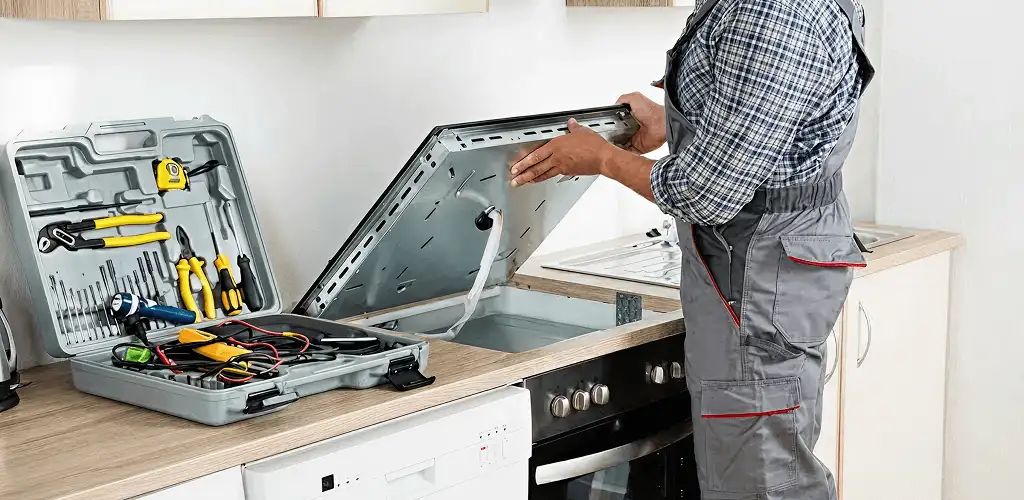 Handyman repairing a cooktop and checking wiring connections in Bradenton, FL