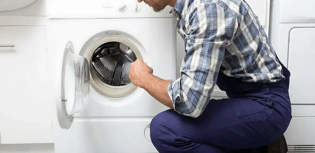 Handyman inspecting a dryer drum and internal parts for repair in Bradenton, FL