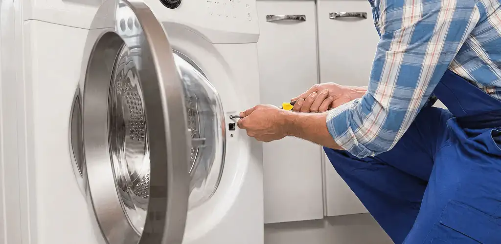 Handyman repairing a clothes dryer and checking electrical connections in Bradenton, FL