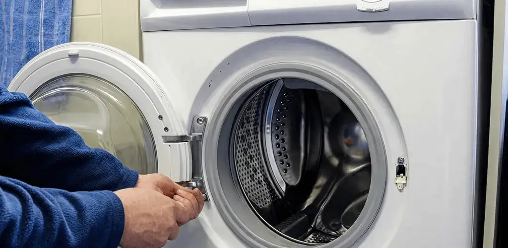 Washing machine repair handyman checking a front-load washer door and latch in Bradenton, FL