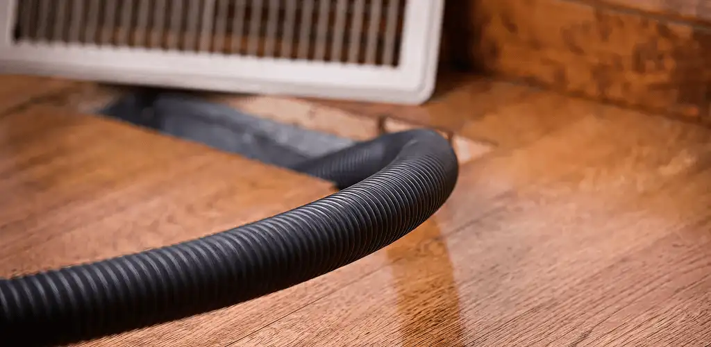 Air duct cleaning hose inserted into a floor vent for ductwork cleaning in Bradenton, FL