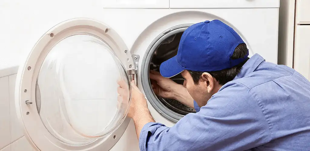 Washing machine repair handyman inspecting a front-load washer drum in Bradenton, FL